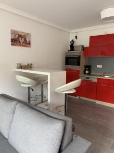 een keuken met rode kasten en een grijze bank bij Apartment Martinstraße 7b in Hannover