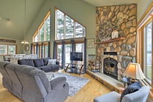 a living room with a large stone fireplace at Cozy Dam Lake Escape with Dock, Yard and Water Access! in Eagle River