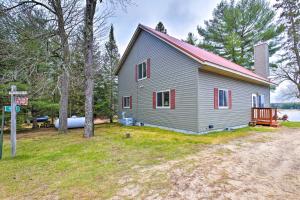 a large gray house with a red roof at Cozy Dam Lake Escape with Dock, Yard and Water Access! in Eagle River