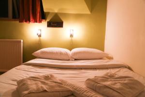 a bed with white sheets and pillows on it at Croft Hotel in Leicester