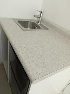 a kitchen sink with a granite counter top at Milenio III B&B in Querétaro