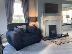 a living room with a chair and a fireplace at Tailors Lodge, Luxurious peaceful Apartment- Castleisland, Kerry in Castleisland