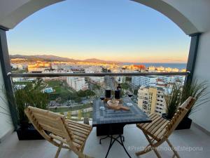 a table and chairs on a balcony with a view at #PrettyPenthouseEstepona in Estepona