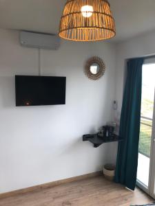 a room with a flat screen tv hanging from a wall at Au pied de la dune in Sangatte