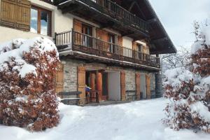 un edificio con balcone nella neve di Paisible chalet montagne avec option jacuzzi a Séez