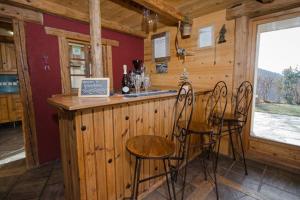 a bar in a cabin with chairs at a counter at Paisible chalet montagne avec option jacuzzi in Séez