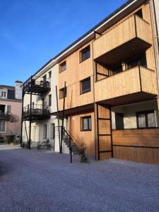 ein Apartmenthaus mit einer Holzfassade und einer Garage in der Unterkunft Le 04-GregIMMO-Appart'Hôtel in Montbéliard