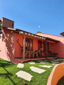 uma casa com um relvado verde em frente em Pousada Camarás em Alto Paraíso de Goiás