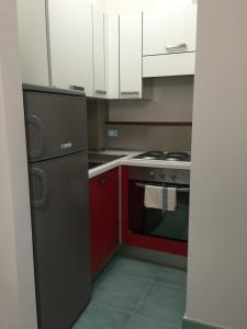 a kitchen with red cabinets and a black refrigerator at Joseph Apartment in San Benedetto del Tronto