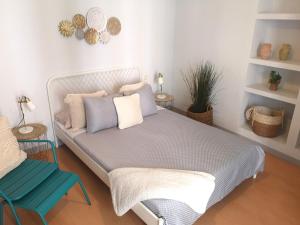 a bedroom with a bed and a blue chair at Apartamentos Fucar in Madrid