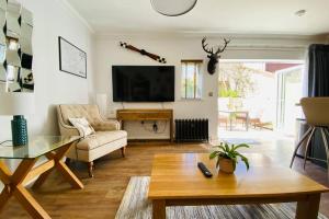 a living room with a couch a table and a tv at Luxury Apartment-Golden Triangle, Parking & Garden in Norwich