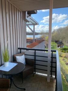 d'une terrasse avec une table et des chaises et une vue sur l'eau. dans l'établissement Labud 20 am Plöner See in Bosau, à Bosau