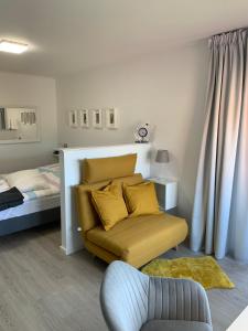 a living room with a yellow couch and a bed at Labud 20 am Plöner See in Bosau in Bosau