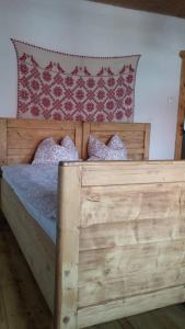 1 cama de madera con 2 almohadas en Casa Emma Ház, en Sovata