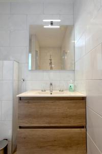 een badkamer met een wastafel en een spiegel bij Costa in Zandvoort