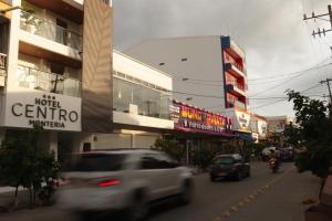a white truck driving down a city street with buildings at Hotel Centro Monteria in Montería