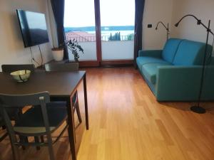 uma sala de estar com um sofá azul e uma mesa em Apartment Rustica em Portorož