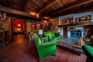 a living room with a green couch and a fireplace at Royo Guarde, junto al río Mundo in Riópar