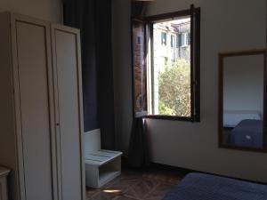 um quarto com uma janela, um espelho e uma cama em Corte Loredana em Veneza