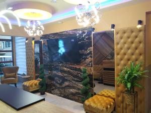 a lobby with a large screen tv and chairs at Baron in Budva
