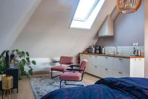 a room with two chairs and a kitchen with a window at B&B De Herenboer in Opeinde