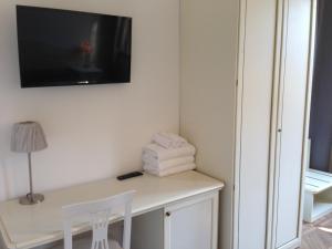 Habitación con escritorio y TV en la pared. en Corte Loredana en Venecia