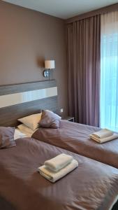 two beds in a hotel room with towels on them at Apartament Czarna Góra B11 in Sienna +14 photos