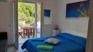 a bedroom with a blue bed and a sliding glass door at Emidio House in Termini