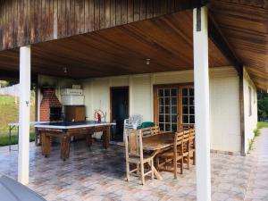 a patio with a ping pong table and chairs at Sítio Santo Agostinho in Porangaba