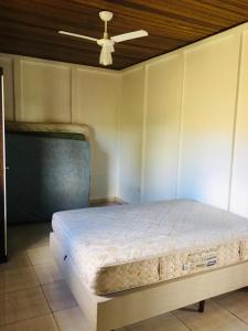 a bedroom with a bed and a ceiling fan at Sítio Santo Agostinho in Porangaba