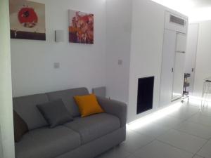 a living room with a gray couch with a yellow pillow at Yialos Luxury Apartments in Pervolia