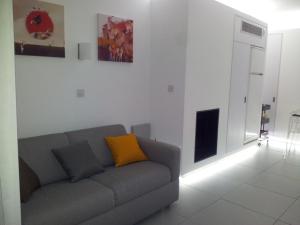 a living room with a gray couch with a yellow pillow at Yialos Luxury Apartments in Perivolia