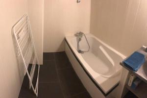 uma casa de banho branca com uma banheira e um lavatório em F3 - NEUF - 4/6 p - lits King size - Wifi - Cour em Le Puy-en-Velay