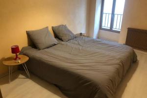 uma cama grande num quarto com uma mesa em F3 - NEUF - 4/6 p - lits King size - Wifi - Cour em Le Puy-en-Velay
