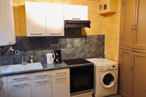 uma cozinha com um lavatório e uma máquina de lavar roupa em F3 - NEUF - 4/6 p - lits King size - Wifi - Cour em Le Puy-en-Velay