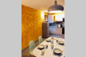 uma sala de jantar com uma mesa e uma cozinha em F3 - NEUF - 4/6 p - lits King size - Wifi - Cour em Le Puy-en-Velay