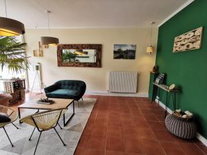 ein Wohnzimmer mit grünen Wänden, einem Sofa und einem Tisch in der Unterkunft Hotel Pension Jägerstieg in Bad Grund