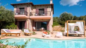 a villa with a swimming pool in front of a house at Amapola Boutique Villas with Sea Access - Agapi in Sivota