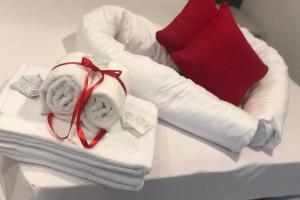 a pile of towels and a pillow on a bed at Villa Teresa.. appartamento “Casa Marta” in Brenzone sul Garda