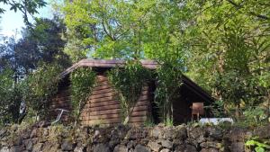 a log cabin sitting on top of a stone wall at Etna Rural Cottage with Jacuzzi in Pedara