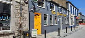 a blue building with a yellow door on a street at Ridge-Rock Accommodation in Carrick on Shannon