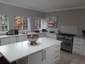 una cocina con armarios blancos y un bol en una encimera en 8 Oyster en Durban