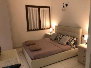 una camera da letto con un letto con due cuscini e uno specchio di Elegante monolocale al centro del paese a Teulada