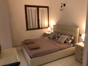 a bedroom with a bed with two pillows and a mirror at Elegante monolocale al centro del paese in Teulada