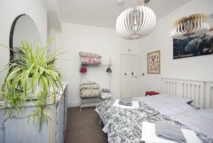 a bedroom with two beds and a potted plant at Enjoy Ventnor 1, Pier Street, Wightlink offer in Ventnor
