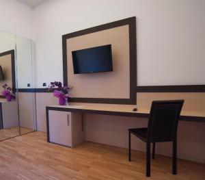 a room with a desk with a chair and a tv at Hotel Louisiana in Rome