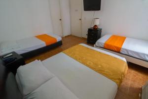 Habitación con 2 camas y TV. en Toscana Suite 10-18, en Cartagena de Indias