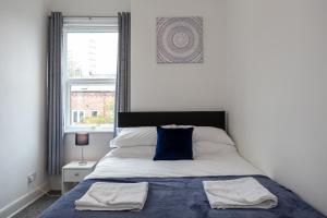 a bedroom with a bed with two towels on it at Stay Comfortable-City Centre Location- Sleeps up to 9 in Stoke on Trent
