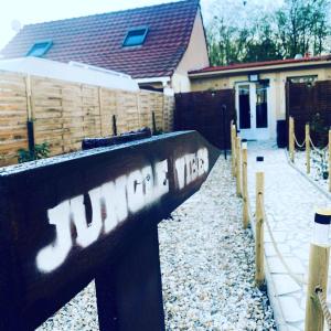 a fence with graffiti on it in front of a house at Jungle Vibes - Jacuzzi - Sauna in Yerres