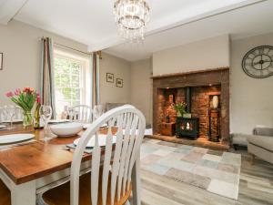 a dining room with a table and a fireplace at Otters Holt in Newby